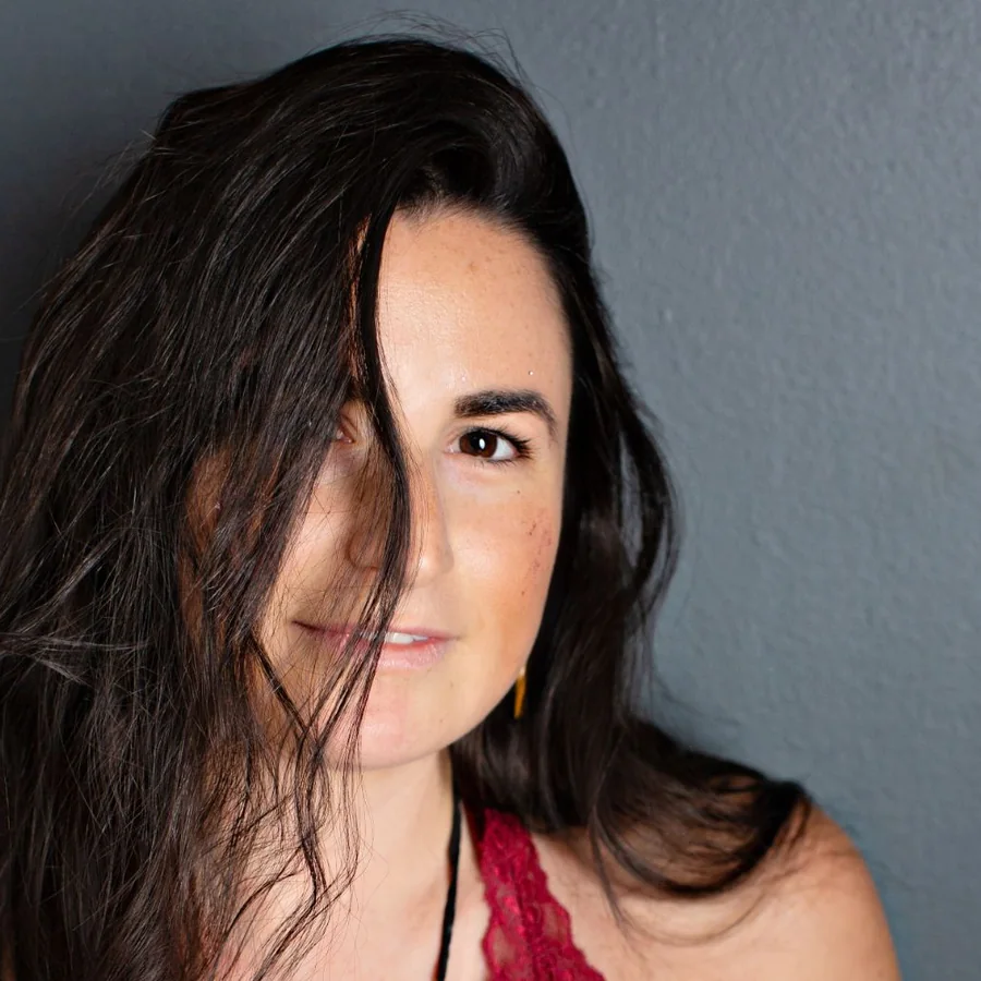 Jade Levinson, with dark hair falling across one eye, looking into the camera